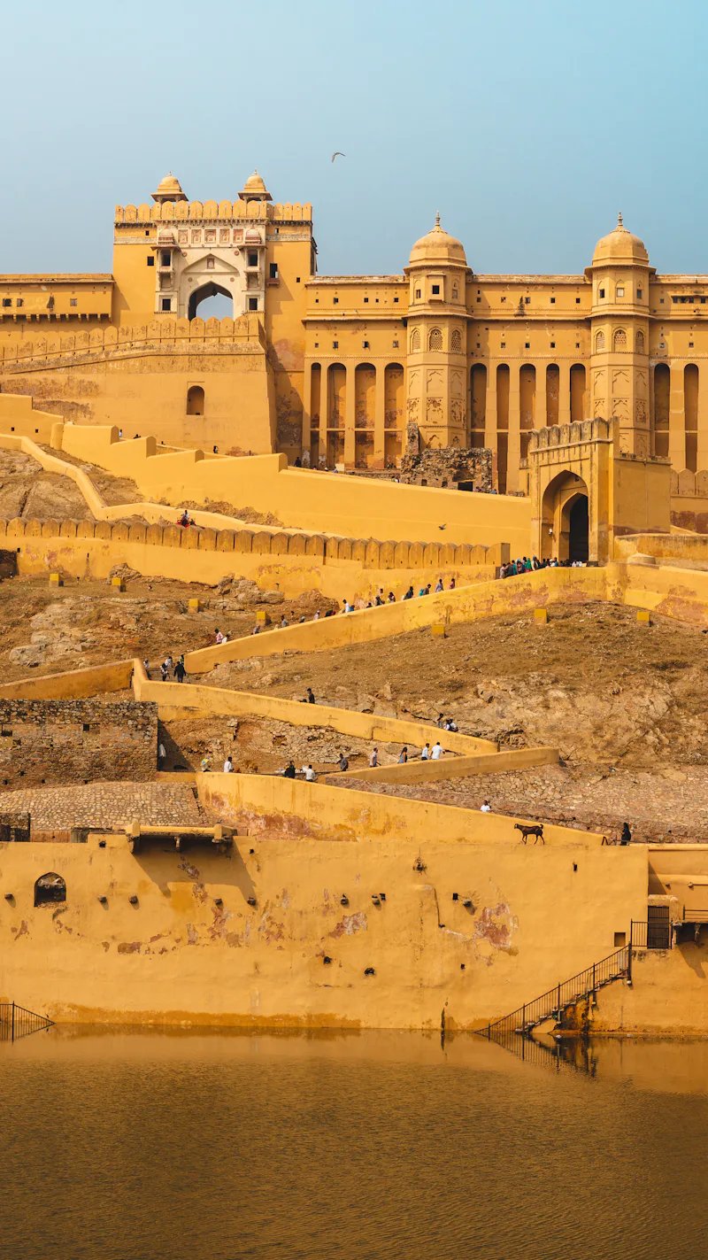Amber Fort glowing gold above the water in Jaipur