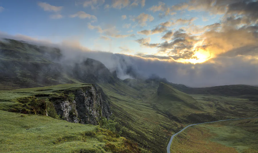 Green hills under drifting cloud and low evening light